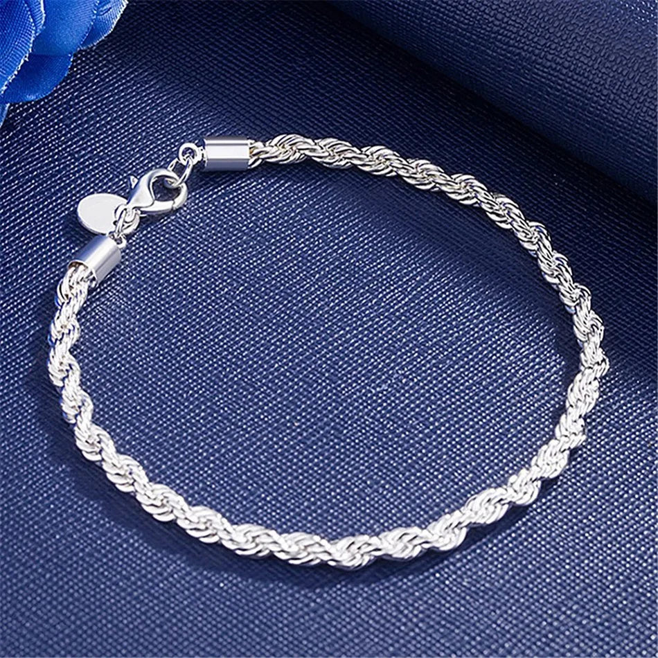 Silver braided bracelet on a blue fabric background