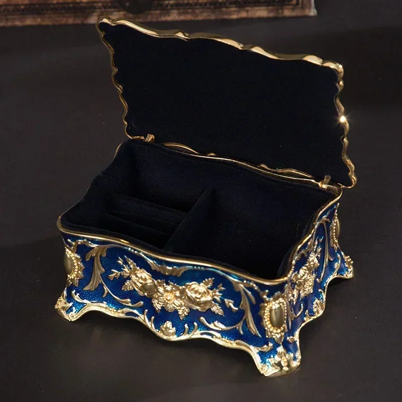 Decorative jewelry box with blue and gold floral patterns on a dark background