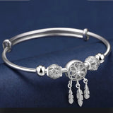 Silver bracelet with decorative beads on a dark blue background