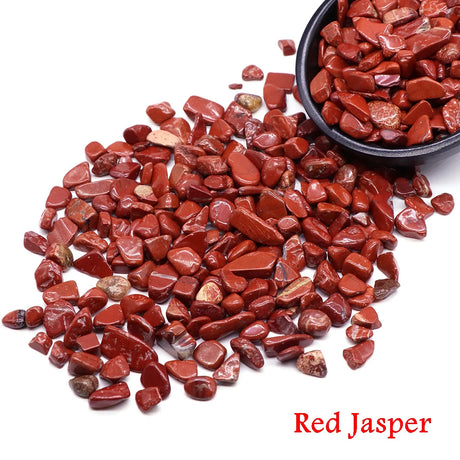 Red Jasper stones with a bowl of stones on a white background.