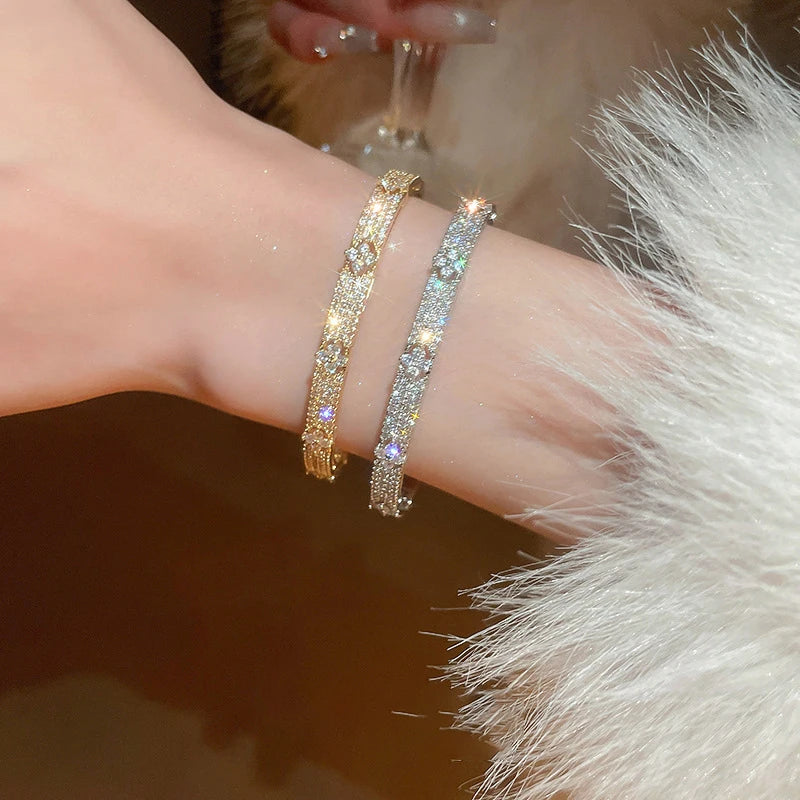 Gold and silver bracelets on a wrist with a soft background