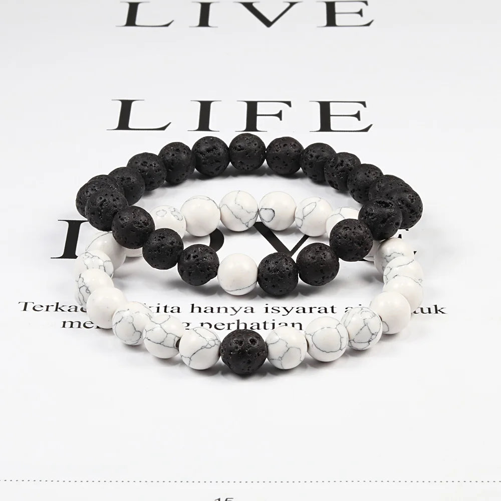 Two black and white beaded bracelets on a magazine page background