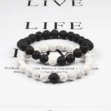 Two black and white beaded bracelets on a magazine page background
