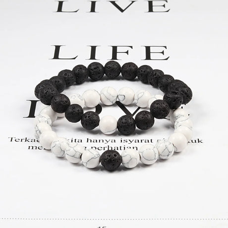 Two black and white beaded bracelets on a magazine page background