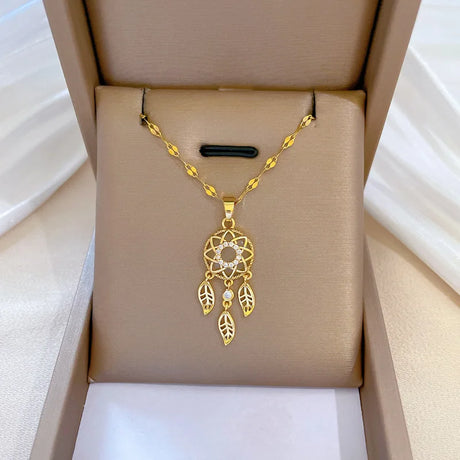 Gold necklace with a dreamcatcher pendant in an open jewelry box.
