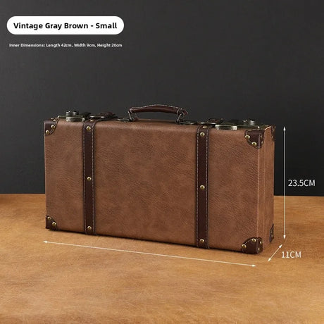 Vintage-style brown suitcase with measurements on a wooden surface and dark background