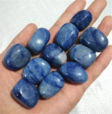 Hand holding a collection of blue stones against a white background