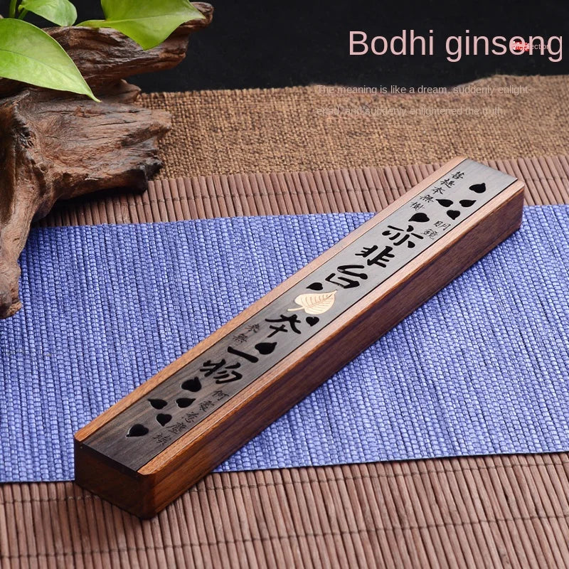 Wooden incense burner with engraved characters on a blue mat, surrounded by natural elements.