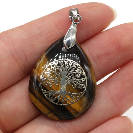 Pendant with tree of life design held in a hand
