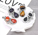 Set of colorful stone pendants on a white stand with 'LOVE' text in the background.