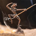 Bronze sculpture of a figure on a rock with a staff, surrounded by smoke.
