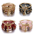 Four beaded bracelets with gold accents on a white background