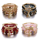 Four beaded bracelets with gold accents on a white background