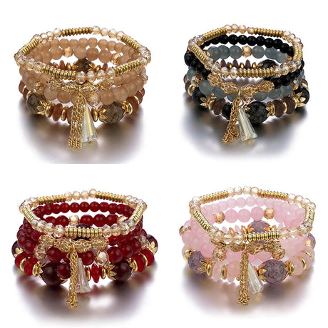 Four beaded bracelets with gold accents on a white background