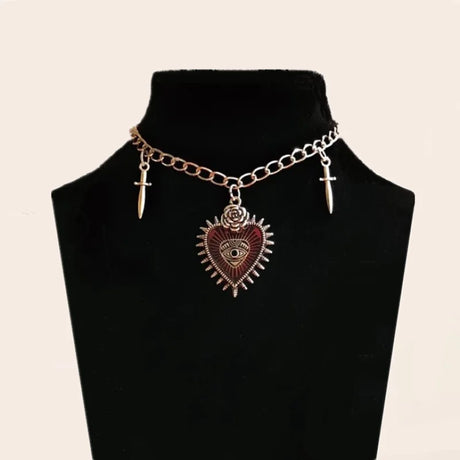 Necklace with heart-shaped pendant and cross charms on a black mannequin bust.