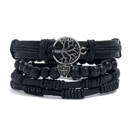 Stack of black bracelets with central metal tree-of-life design on a white background