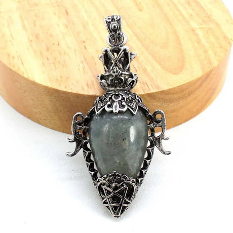 Silver pendant with a central stone on a wooden background