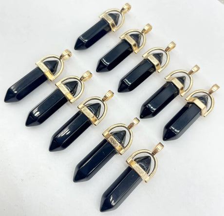 Black crystal pendants with gold accents arranged on a white background