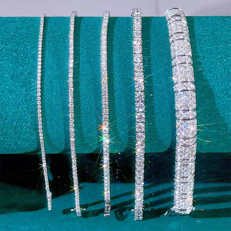 Set of diamond-encrusted bracelets on a green background