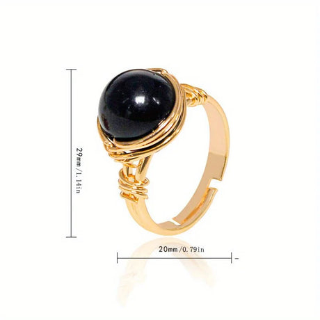 Gold ring with a black gemstone and measurements on a white background