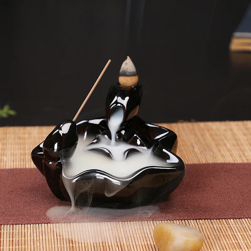 Black and white incense burner with incense sticks on a woven mat