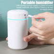 Portable humidifier with USB interface being charged by a hand on a neutral background