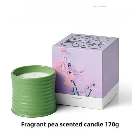 Fragrant pea scented candle in a green container with packaging featuring floral design on a white background