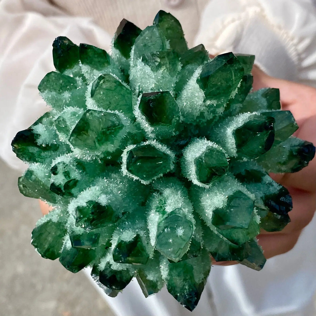 Close-up of a green crystal formation held by a person