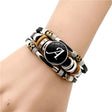 Multistrand bracelet with a central black disc featuring a white letter 'A' on a wrist.