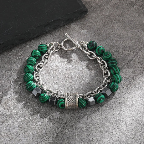 Bracelet with green beads and silver chain on a gray surface