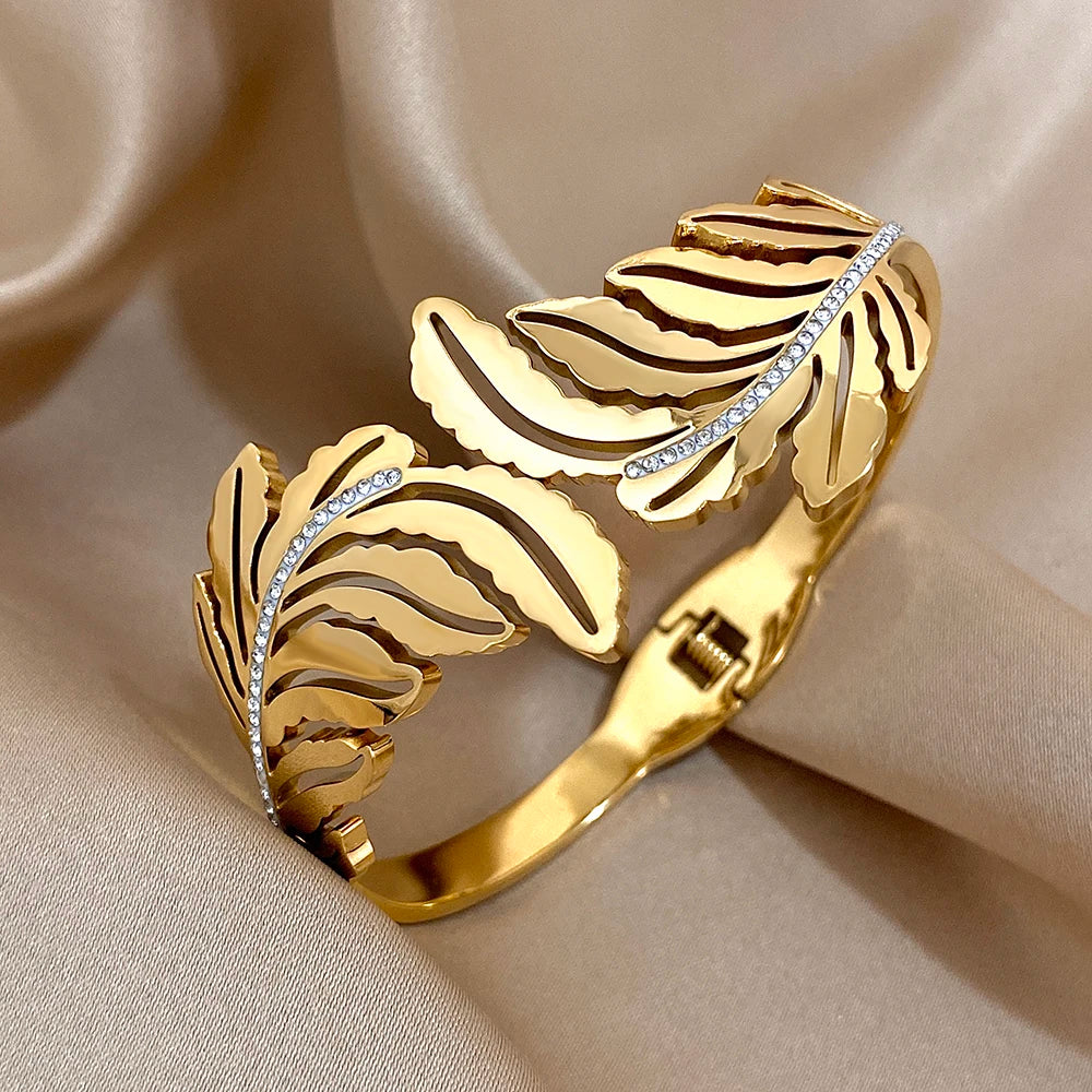 Gold bracelet with leaf design on a beige fabric background