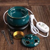 Teal ceramic warmer with control unit on a wooden surface