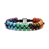 Set of four beaded bracelets with a central silver OM symbol charm on a white background