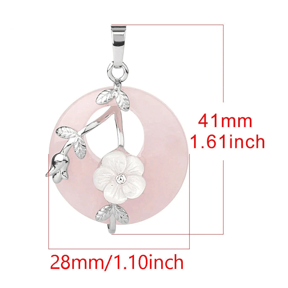 Pink circular pendant with floral design and measurements on a white background