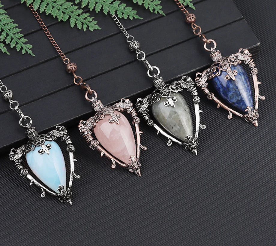 Four gemstone pendants on chains with a brand logo in the corner.