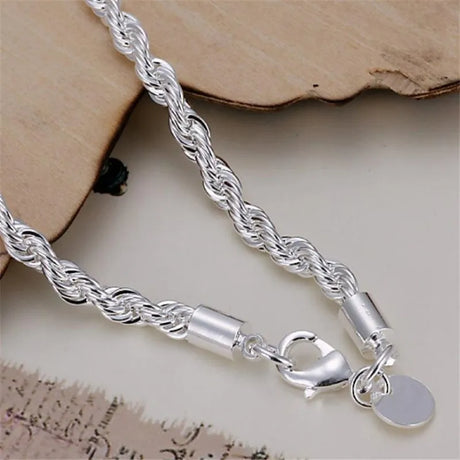 Silver chain bracelet with a clasp on a textured surface