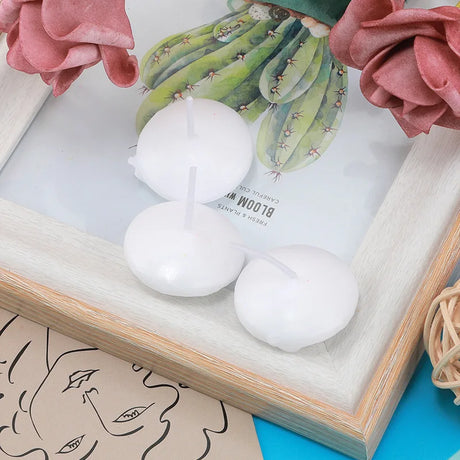 White spherical bath bombs with a cactus illustration and flowers on a wooden tray.
