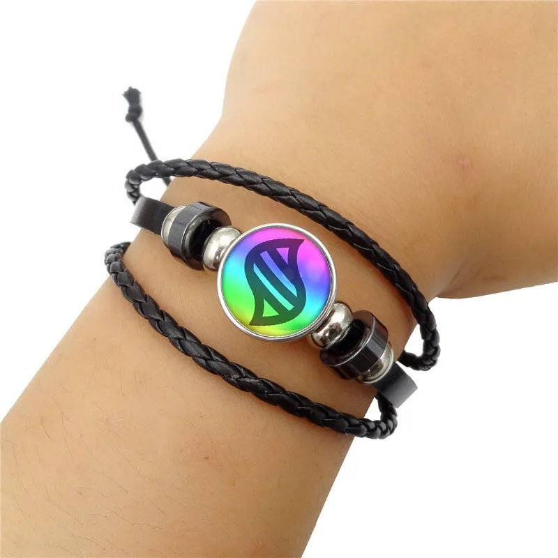 Black braided bracelet with a colorful circular charm on a wrist against a white background