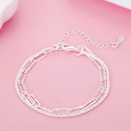 Silver chain bracelet on a pink background
