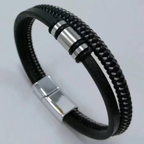 Black braided leather bracelet with silver metal clasp on a light gray background