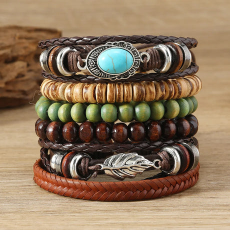 Stack of leather and beaded bracelets with turquoise stone and metal leaf design on a wooden surface.
