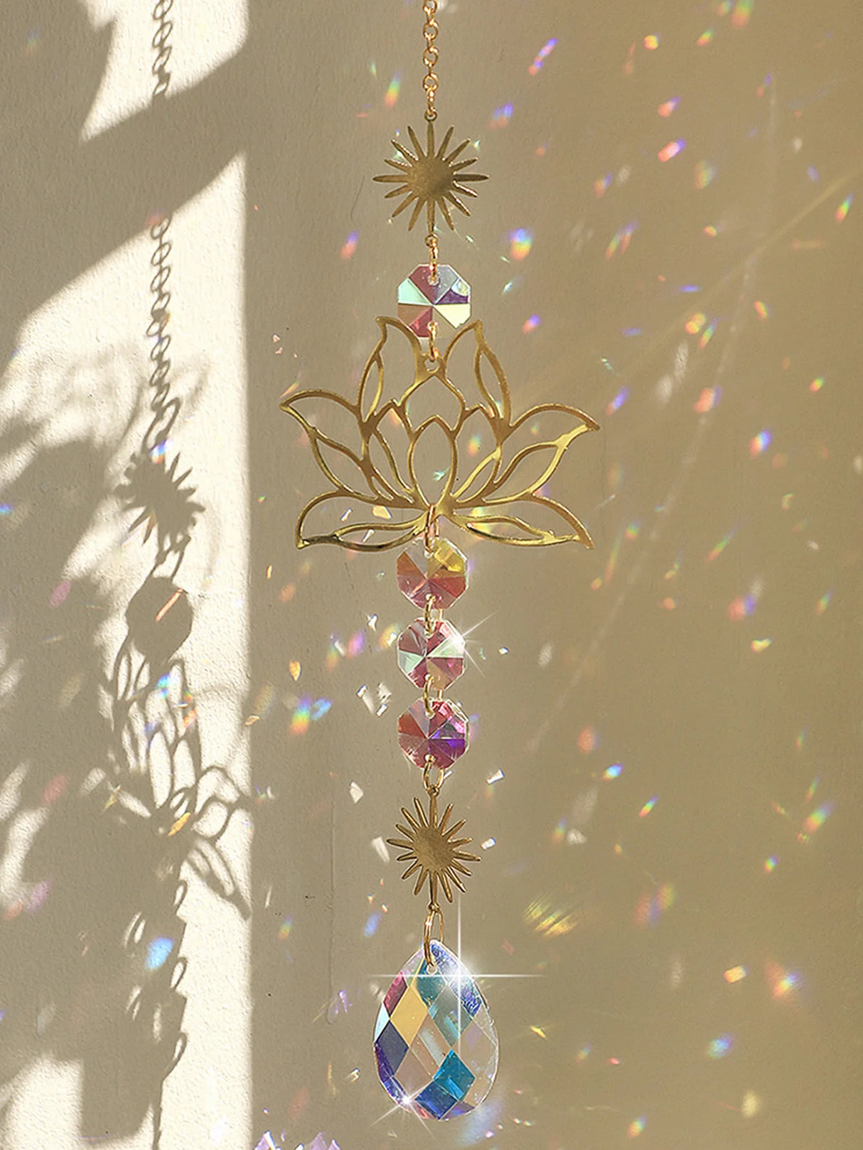 Decorative gold lotus flower with colorful crystals hanging against a light background