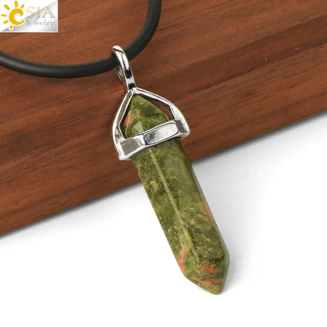Green stone pendant with silver setting on a wooden surface, CTA Jewelry logo visible.