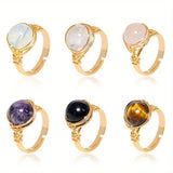Set of six gold rings with different gemstones on a white background