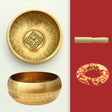 Two brass singing bowls on a white background with a red background featuring a decorative ring.
