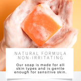 Bar of soap with a block of orange soap on top, against a yellow background.