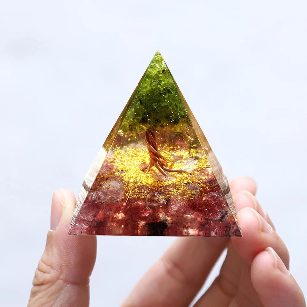 Triangular crystal with colorful interior held between fingers against a light background