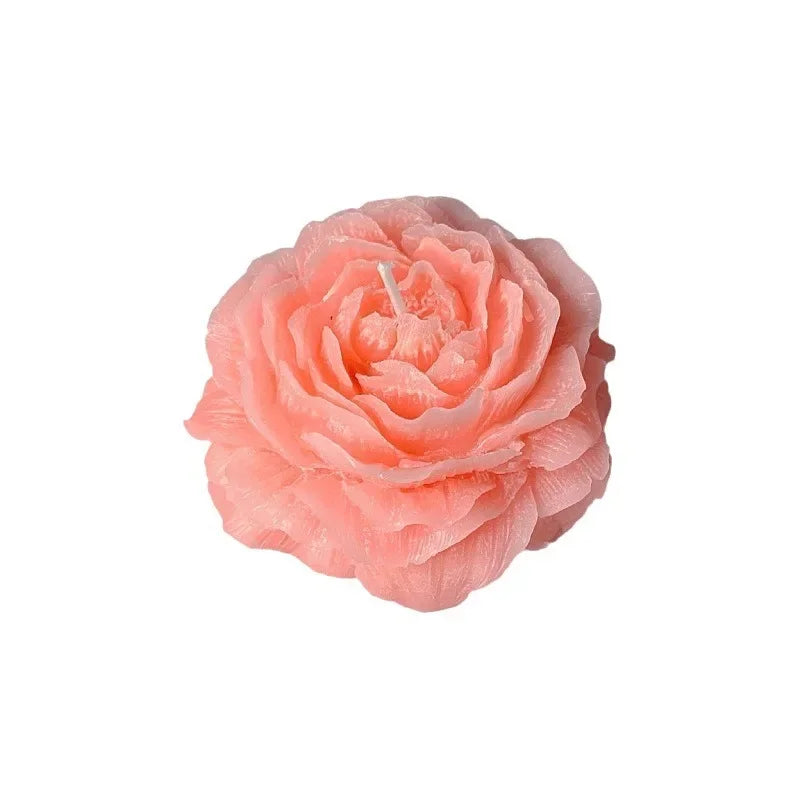 Pink rose-shaped candle on a white background