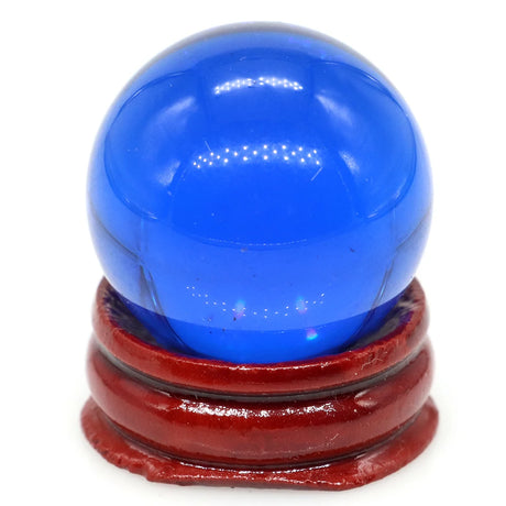 Blue glass sphere on a red wooden stand against a white background
