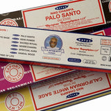 Stack of Satya Nag Champa incense packaging with product details.